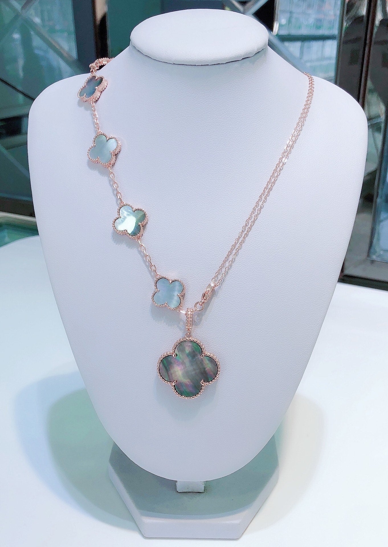 ```json
[
  {
    "Clover Jewelry": "KLEEBRIFURM BAND MIT 5 MOTIVEN UND HALSKETTE AUS DUNKLEM PERLMUTT ROSÉGOLD"
  }
]
```