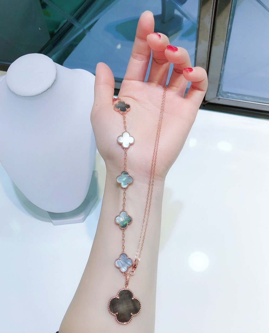 ```json
[
  {
    "Clover Jewelry": "KLEEBRIFURM BAND MIT 5 MOTIVEN UND HALSKETTE AUS DUNKLEM PERLMUTT ROSÉGOLD"
  }
]
```