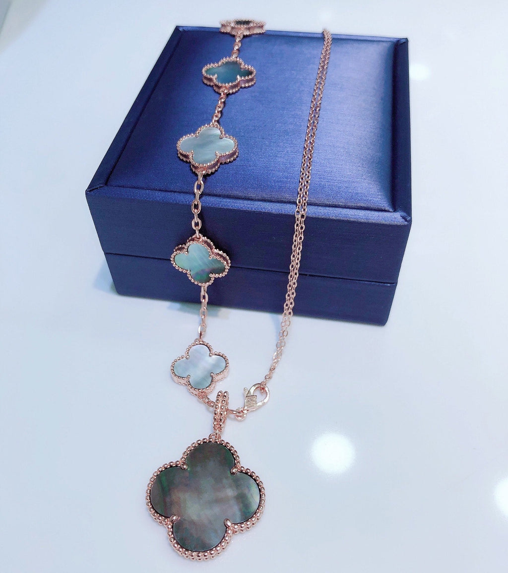 ```json
[
  {
    "Clover Jewelry": "KLEEBRIFURM BAND MIT 5 MOTIVEN UND HALSKETTE AUS DUNKLEM PERLMUTT ROSÉGOLD"
  }
]
```