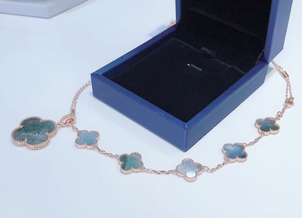 ```json
[
  {
    "Clover Jewelry": "KLEEBRIFURM BAND MIT 5 MOTIVEN UND HALSKETTE AUS DUNKLEM PERLMUTT ROSÉGOLD"
  }
]
```