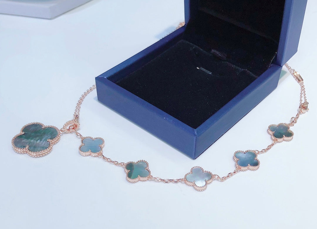 ```json
[
  {
    "Clover Jewelry": "KLEEBRIFURM BAND MIT 5 MOTIVEN UND HALSKETTE AUS DUNKLEM PERLMUTT ROSÉGOLD"
  }
]
```